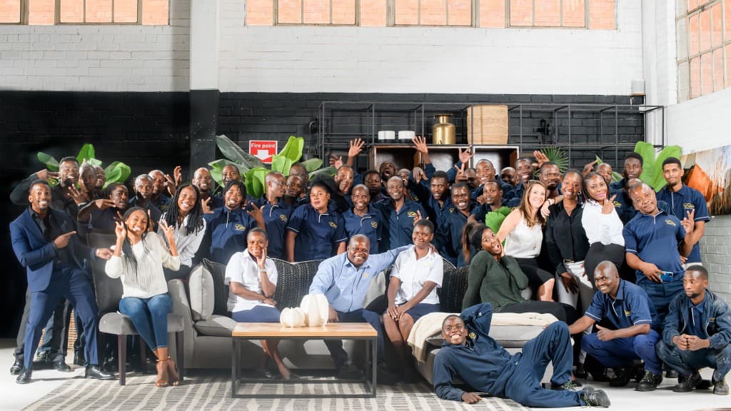 Wide group portrait of the Elite Interiors team with showroom furniture.